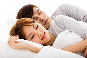 躺在床上的快乐年轻可爱夫妇