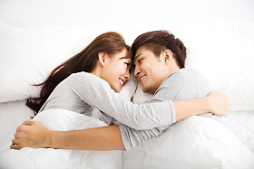 躺在床上的快乐年轻可爱夫妇图片