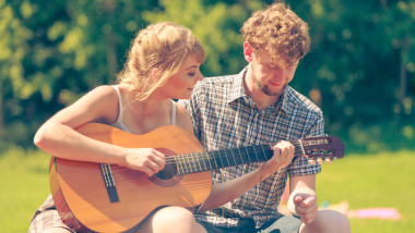 對年輕的夫婦戶外野營玩吉他圖片