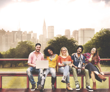 坐在长椅上与笔记本电脑的朋友