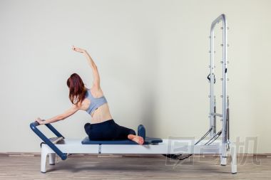 普拉提的改革者鍛煉鍛煉女人黑發(fā)在健身房室內(nèi)