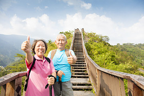 幸福的高级夫妇徒步用拇指山