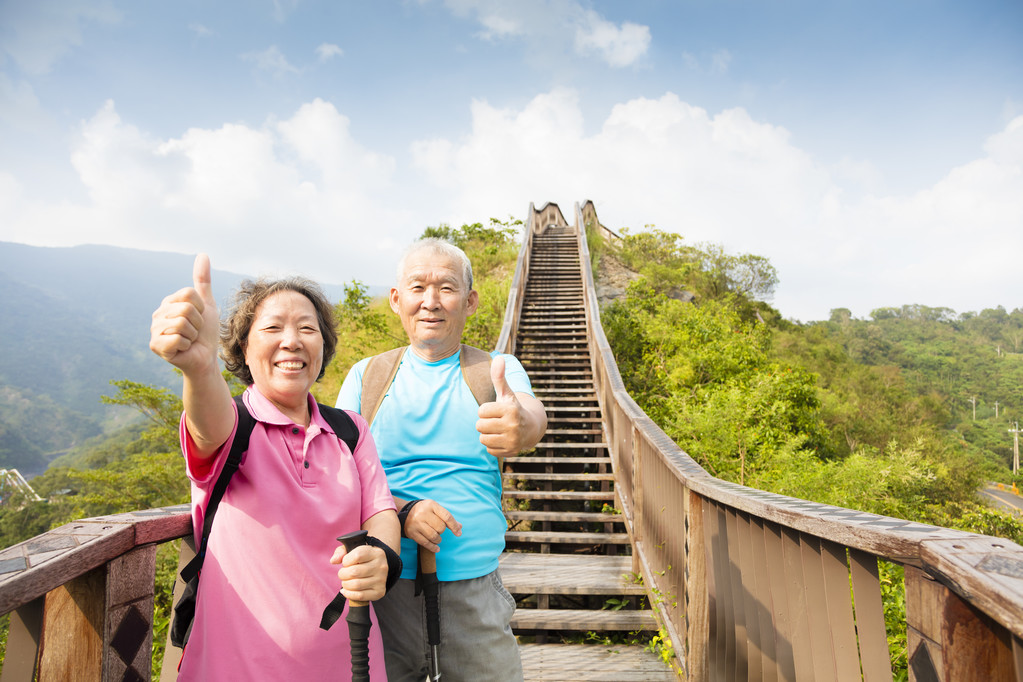 幸福的高级夫妇徒步用拇指山