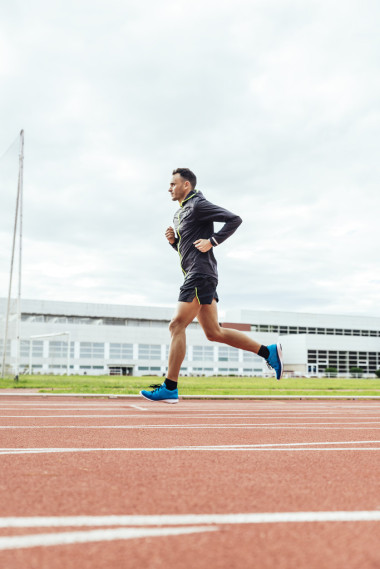 有魅力的男人運動員運行上磁道