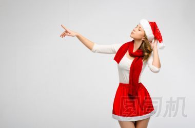 圣誕圣誕老人帽子孤立的女人肖像?？雌饋矸旁谝贿?，在灰色的背景上。穿白色和紅色衣服的女孩