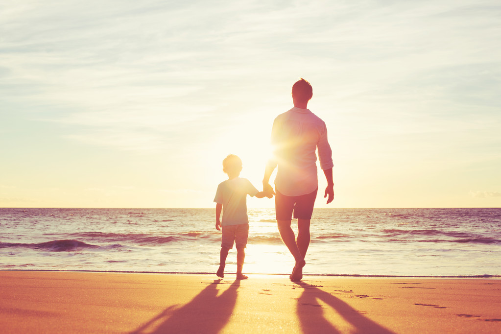 父亲和儿子走在一起，手牵着手