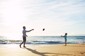 父亲和儿子玩抓投掷足球照片