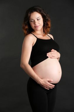 在黑色背景上的年輕快樂(lè)孕婦