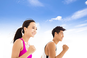 快乐的年轻夫妇，慢跑对多云的天空