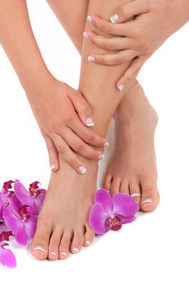 pedicured 的腳、 修剪整齊的手和蘭花