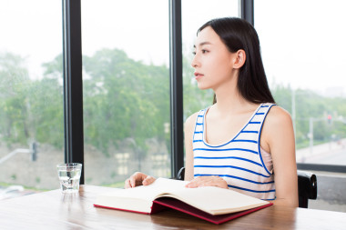 文靜的女孩在咖啡館里看書(shū)