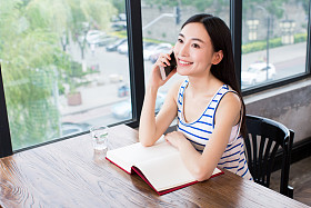 书和移动电话的女人图片