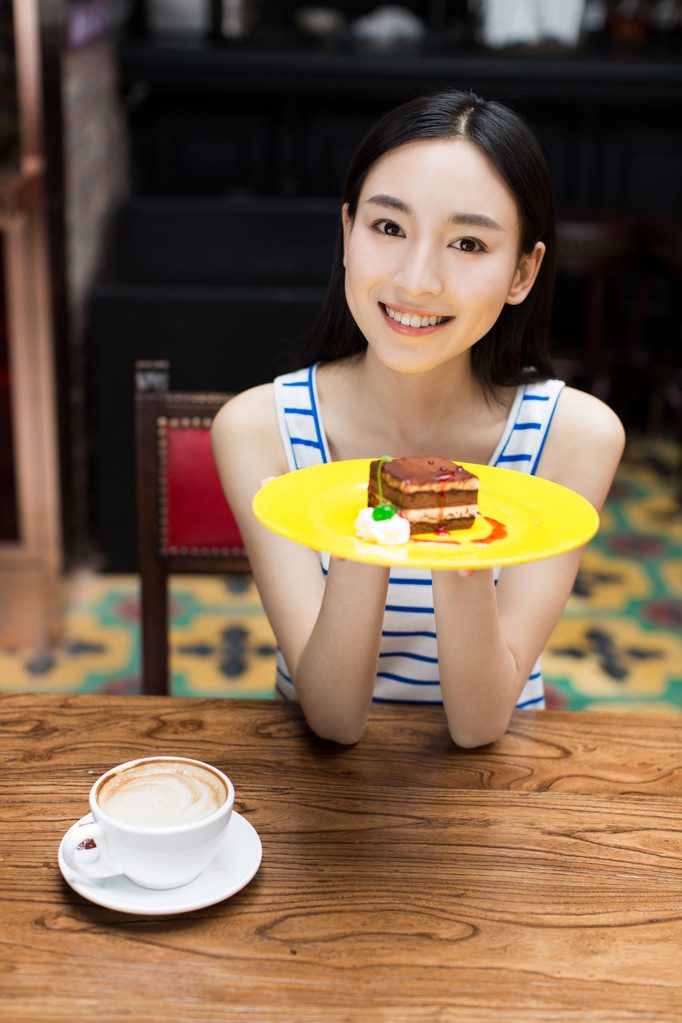 年轻美丽的女人在吃甜点图片
