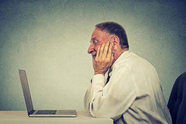 老人使用手提電腦閱讀電子郵件消息。電子學(xué)習(xí)概念