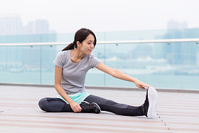 在室外伸展的运动型女人照片