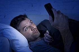 男人深夜在家里的床上沙发上用手机