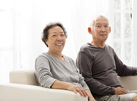 高级夫妻坐在沙发上一起关闭