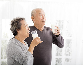 幸福的亚洲高级夫妇喝牛奶