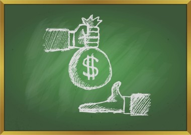 手拿錢給另一只手與黑板背景