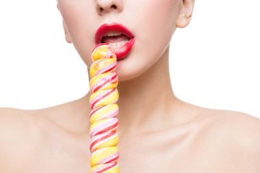 特寫鏡頭的女人嘴鮮紅的嘴唇與棒棒糖。口交仿真