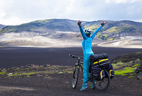 冰岛火山山脉的背景下对快乐骑自行车的人