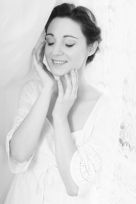 眼睛闭上的画面素雅美丽的年轻女子身穿白色连衣裙快乐的微笑在复制空间薄纱窗帘背景上