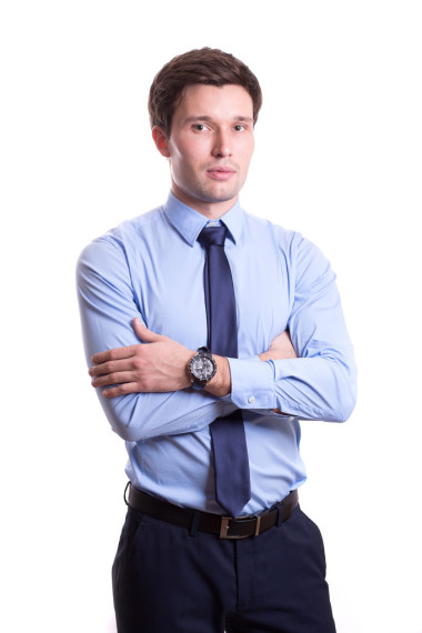 一位英俊的年輕男子的近照身著辦公室服裝系著藍色襯衫長褲領帶孤立地站在白色的背景上