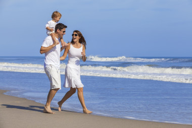 在沙灘上玩的快樂的男人女人孩子家庭