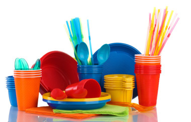 明亮的塑料餐具和餐巾上白色隔離