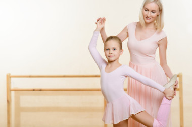 老師幫助女孩保持姿勢.圖片