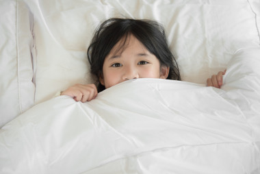 在床上的可愛亞洲 childrplaying