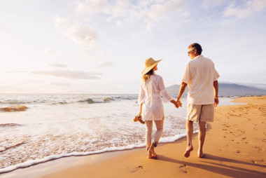 成熟夫妻在日落時(shí)分在沙灘上散步