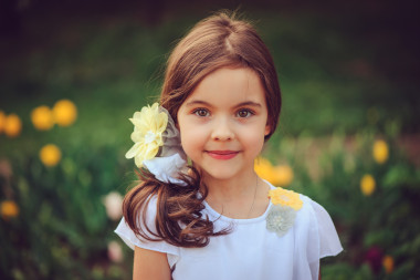 夏天的戶外肖像可愛微笑的小女孩與黃色的花的背景