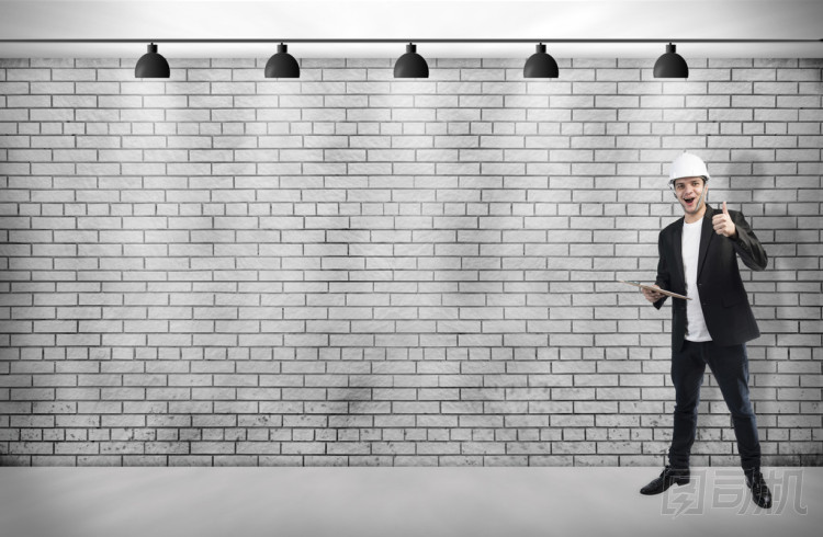 一位年輕英俊的男人建筑師與吸頂燈白色磚墻上