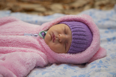 剛出生的嬰兒，在熊的服裝照片