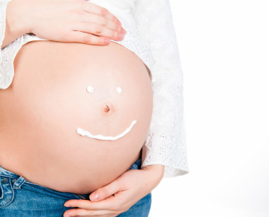 懷孕女性青年與美容霜在肚子上