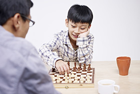 亚洲的父亲和儿子下棋图片