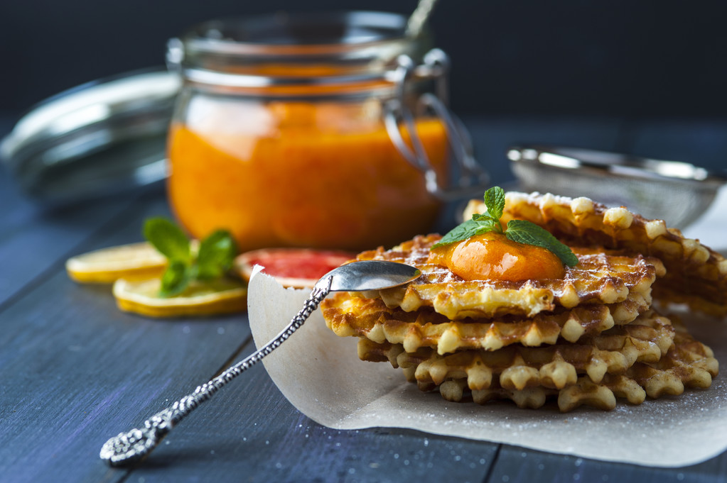 晶片的果酱和银勺子在纸上滴图片