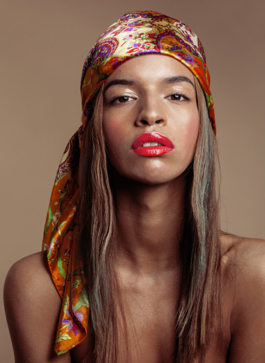 美年轻黑人的美国女子在披肩在附近微笑赃物的头上