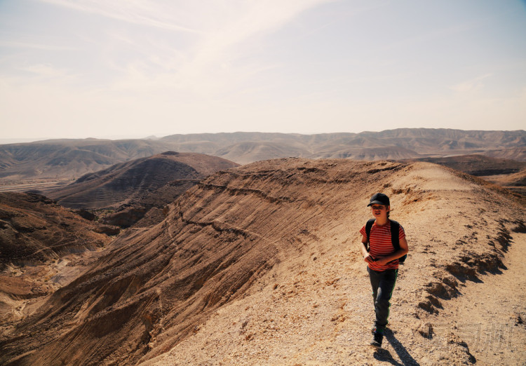 男孩在沙漠中徒步旅行照片