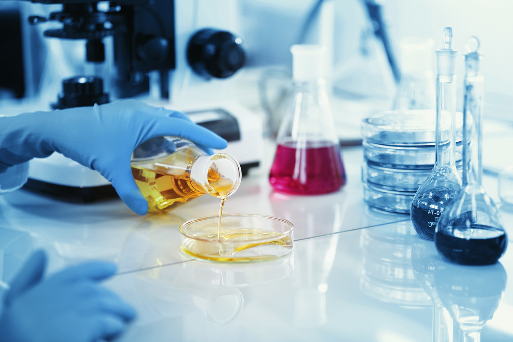 Science, chemistry, technology, biology, human concepts -- young female scientists mix reagents from inside glass flasks and test or study them in clinical laboratories