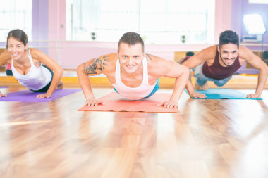 兩名年輕男子和亞洲女孩做俯臥撐室內(nèi)