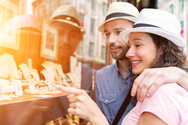 年轻的夫妇在看珠宝商店前面的爱