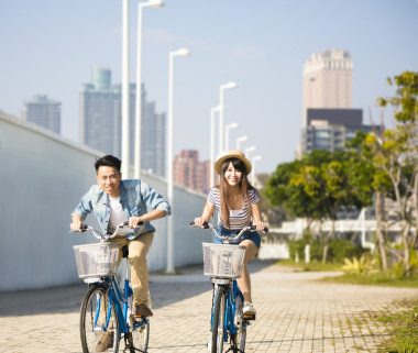 快樂的年輕夫婦，騎著自行車在城市公園