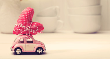 微型粉紅色的車攜帶紅色心形靠墊