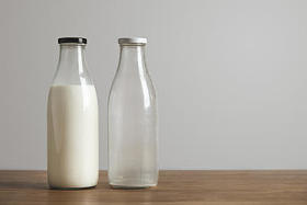 简单的旧瓶装新鲜牛奶和空的