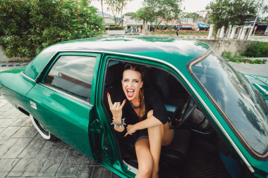 漂亮的女孩坐在一輛老式的汽車