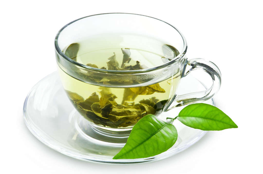 与绿茶和绿色的树叶杯.照片