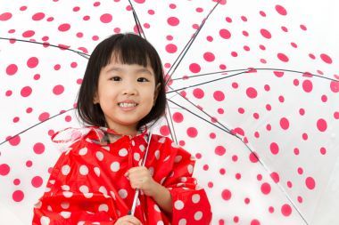 中國(guó)小女孩拿著雨傘和雨衣
