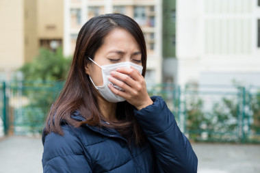 亞洲的年輕女人生病，戴著口罩